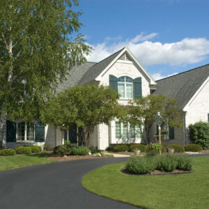Beautiful white two story brick home. Very colorful photo with blue sky and green grass. Typical new home in the suburbs of the United States. Just one of many home or house photos in my gallery.